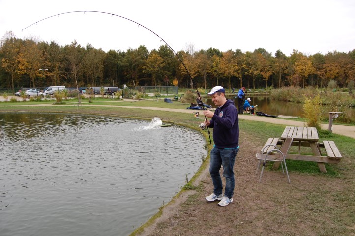 Fighting a big fish in a fishing pond